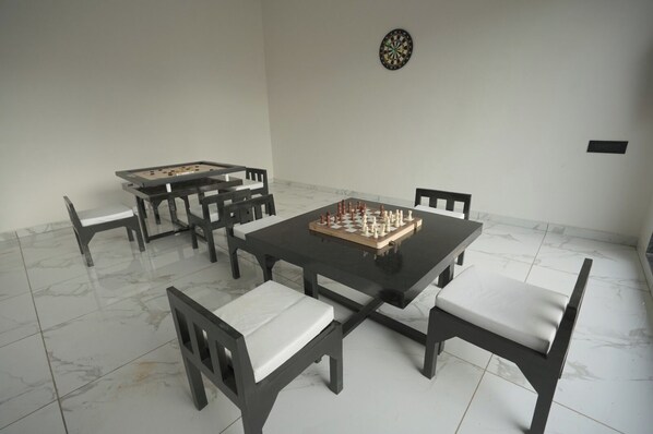 A dining area with a chessboard, a dartboard, and a foosball table. - Cloud9 Club Resort (A Unit of Dawon Hospitality) (Sasan Gir)