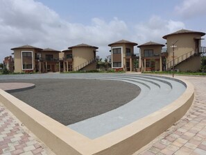 A modern building complex with multiple residential units, a central courtyard, and a paved walkway.