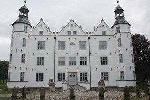 A large, white, multi-story building with symmetrical architecture, featuring prominent towers and a central entrance. - "At Hahnheide" || Linau (Linau)