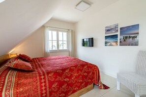 A bedroom with a large bed, a television, and three wall-mounted pictures. - Holiday home with 2 bedrooms (18445 Kramerhof, Deutschland)