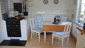 Une cuisine avec un plan de travail blanc, une table en bois et une cuisinière.