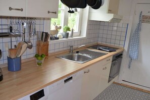 Eine Küche mit einer Holzausziehtafel, einer Spüle und einem Geschirrspüler.