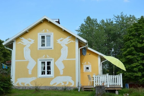 A yellow house with white window frames and a white porch. - Holiday home with 2 bedrooms (Mariannelund)