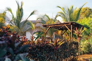 A wooden pergola structure amidst lush tropical vegetation. - Beachside Villa - Pool, WiFi, AC & Kitchen (Pwani Mchangani)