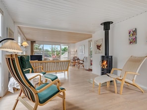 A spacious living area with a wooden floor, a large window, a fireplace, and modern furniture. - "Jale" - 300m from the sea by Interhome (Thisted)