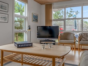 A modern living room with a flat-screen TV, a table with a board game, and a sofa. - "Jale" - 300m from the sea by Interhome (Thisted)