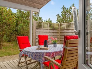 An outdoor patio with a round table, two red chairs, and a wooden fence. - "Jale" - 300m from the sea by Interhome (Thisted)