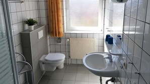 Ein modernes Badezimmer mit Toilette, Waschbecken und Dusche.