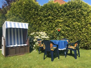 A garden with a striped canopy and outdoor furniture. - Apartment 'Haus Hanning 2' with Shared Garden and Wi-Fi (Wangerland)