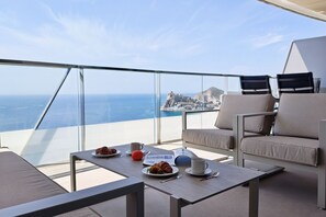 Ein Balkon mit Frühstückstisch und Blick auf die Küste.
