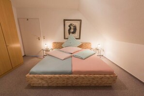 A single bed with a wooden frame, two bedside tables, and a wall-mounted picture. - Forest holiday apartment Hamburg 1 (Rosengarten)