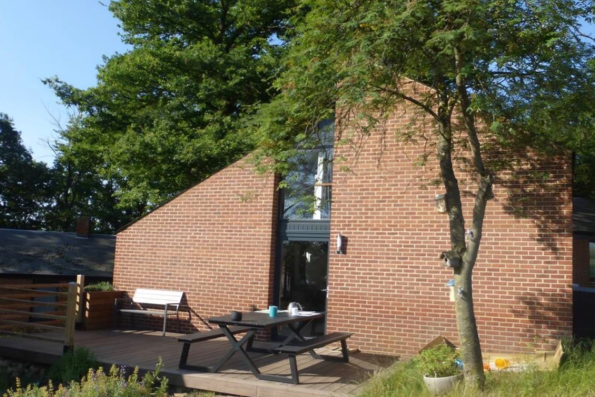 A brick building with a patio area featuring a bench and picnic table.
