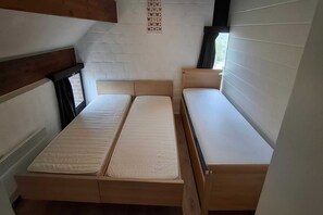 A room with two beds, a window, and a wall-mounted butterfly art piece. - Charming holiday home with a beautiful view (Blaimont)
