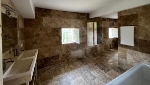 A spacious bathroom with a large bathtub, a double sink, and a shower area. - Bastide du Luberon (APT)