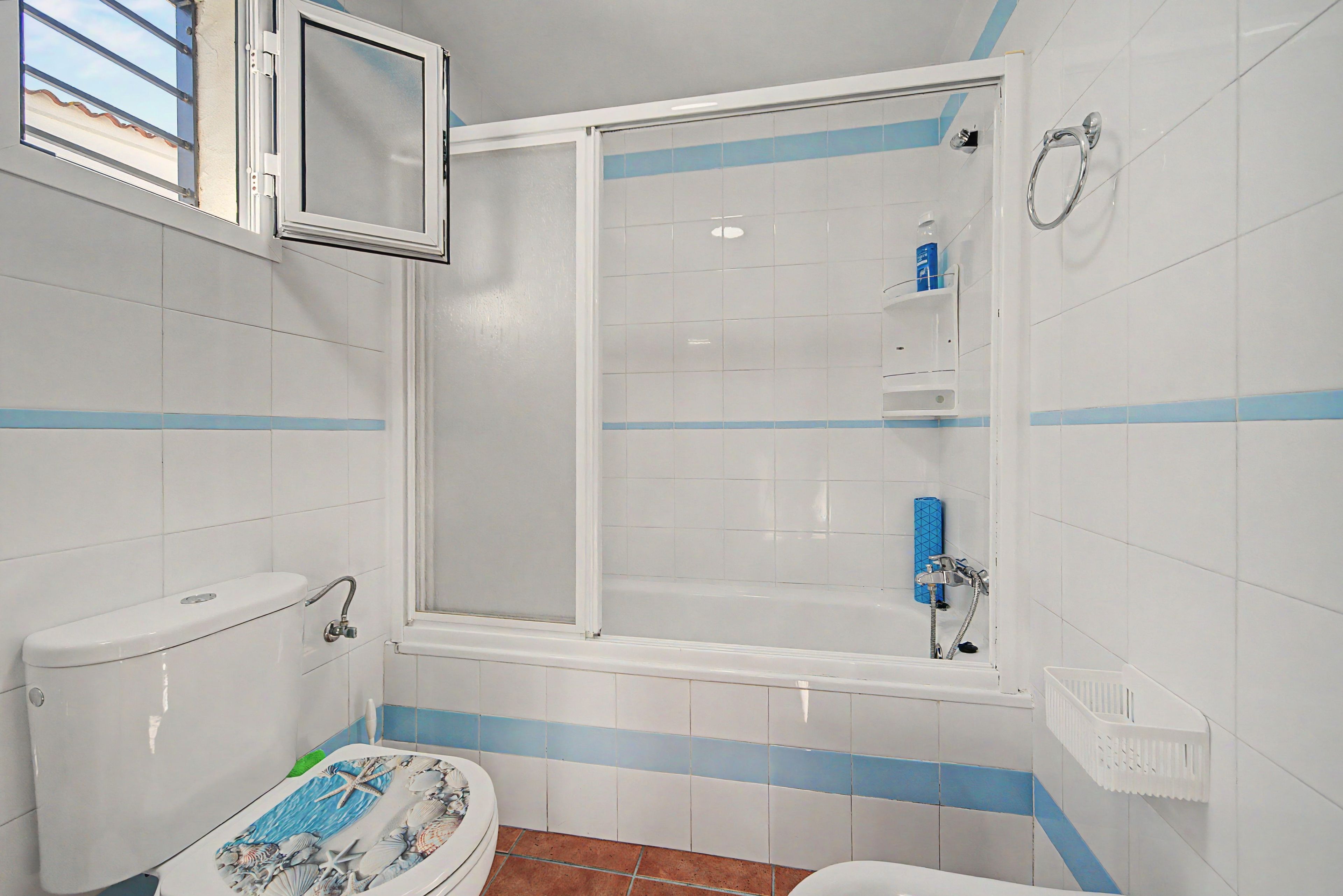 Une salle de bain avec des toilettes, une douche et une baignoire.