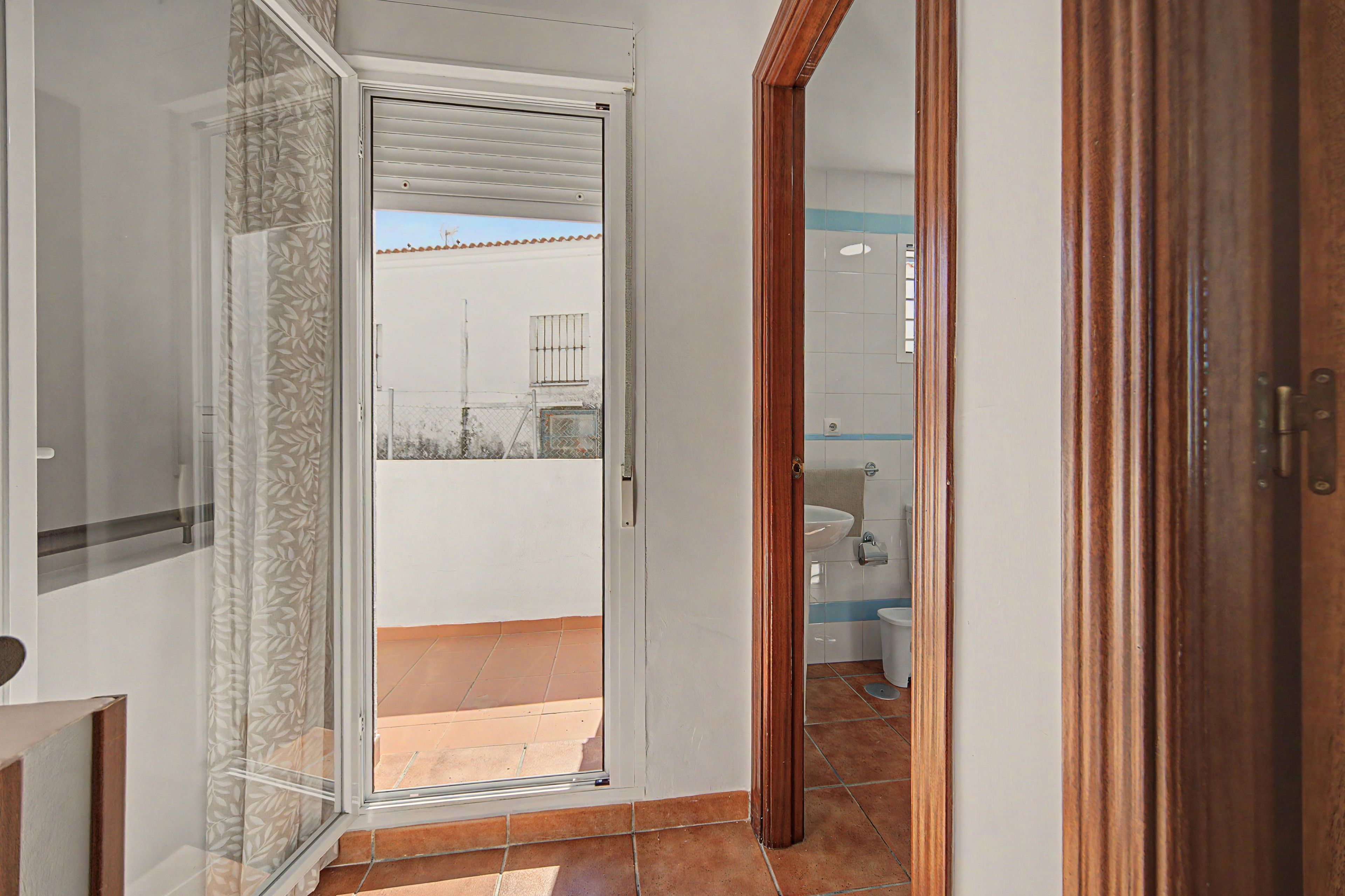 Un baño con lavamanos, inodoro y zona de ducha.