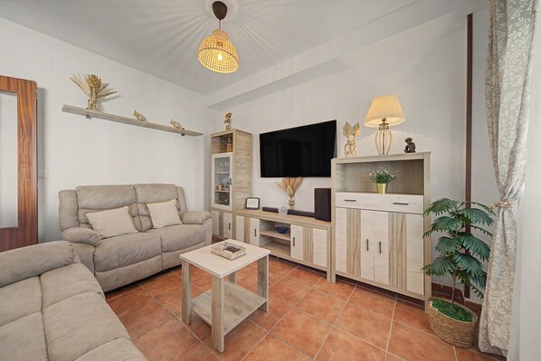 A living room with a sofa, a coffee table, a TV, and a cabinet.