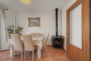 A dining area with a table, chairs, and a fireplace.