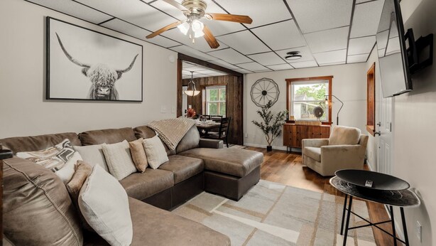 A modern living room with a sectional sofa, a dining area, and a ceiling fan. - Lantz Retreat  Hot Tub • Spacious Deck (Lebanon)