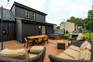 Una terraza con mobiliario exterior, un jacuzzi y una parrilla.