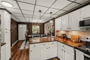 A kitchen with white cabinets, a wooden countertop, and a stainless steel stove. - Lantz Retreat  Hot Tub • Spacious Deck (Lebanon)