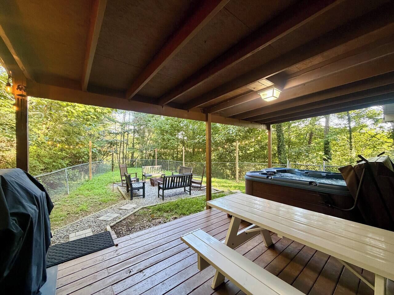 Un patio exterior con jacuzzi, terraza de madera y zona de estar.