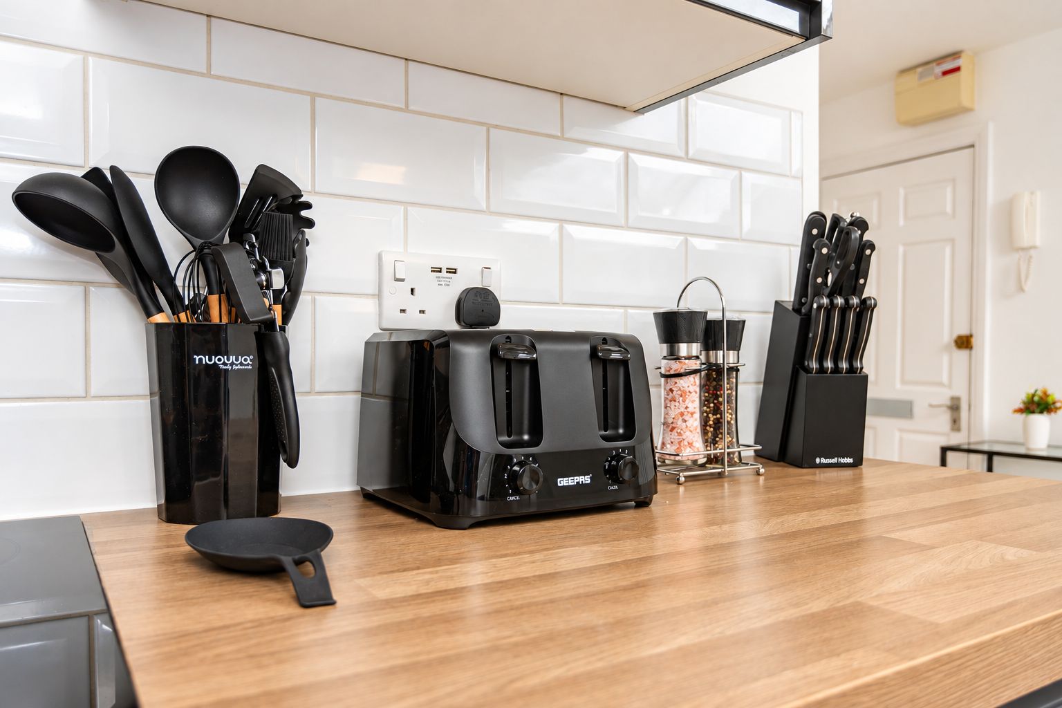 Eine Küche mit einem Toaster, einer Kaffeemaschine und einem Messerblock auf der Arbeitsfläche.