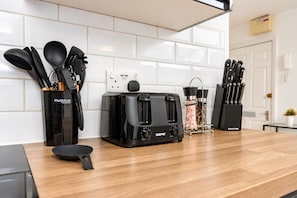 A kitchen with a toaster, a coffee maker, and a knife block on the counter.