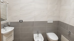 Ein modernes Badezimmer mit Waschbecken, Bidet und Toilette.
