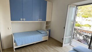Ein Schlafzimmer mit einem Bett, einem Kleiderschrank und einem Balkon.