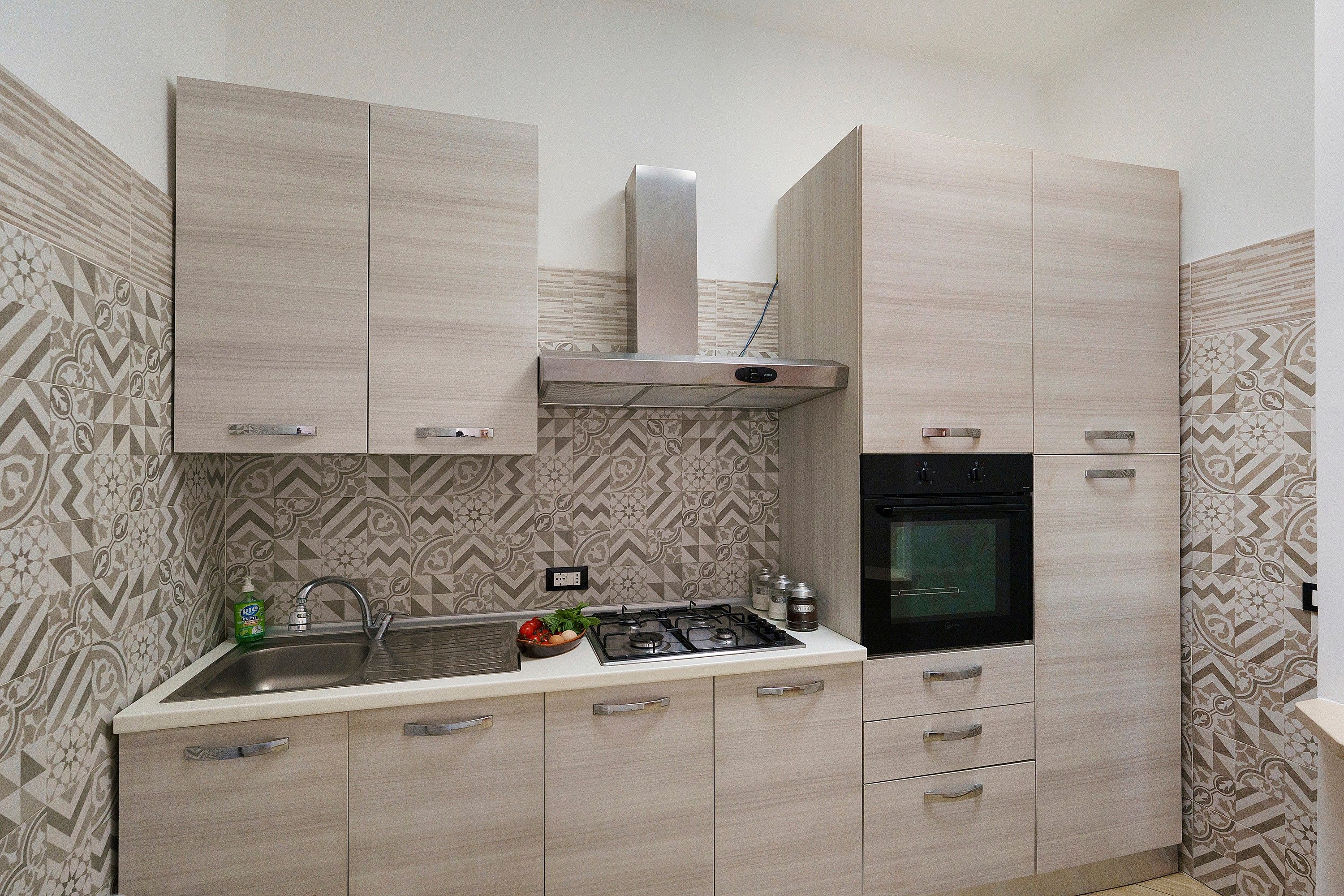 A modern kitchen with a gas stove, oven, and built-in cabinets.