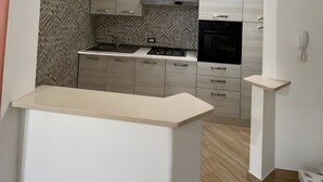 Eine moderne Küche mit Kochinsel, eingebauten Geräten und einer fliesenverzierten Spritzschutzwand.