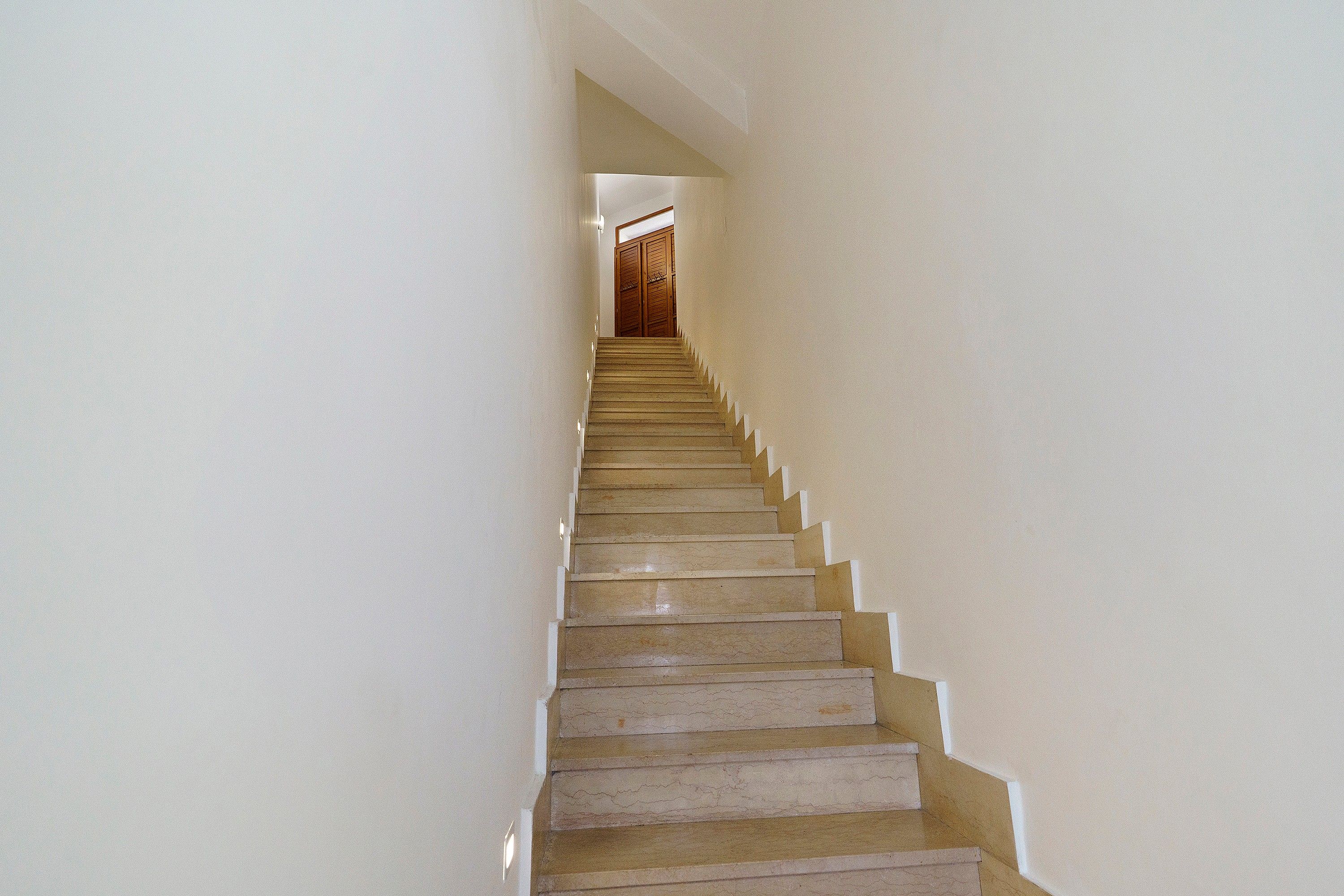 Una scala con ringhiera che porta a un pianerottolo.