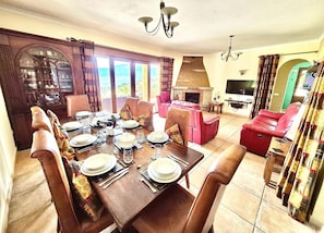 A dining area with a wooden table set for a meal, surrounded by chairs.