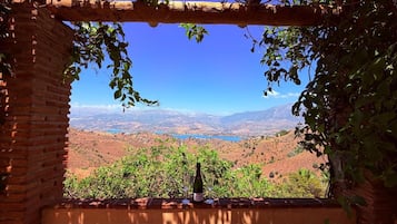 A rustic brick structure with a view of a mountainous landscape and a body of water.