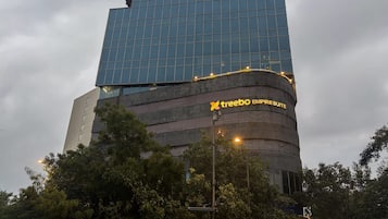 A modern building with a glass facade and a sign for 'Treebo Empire Suite.'