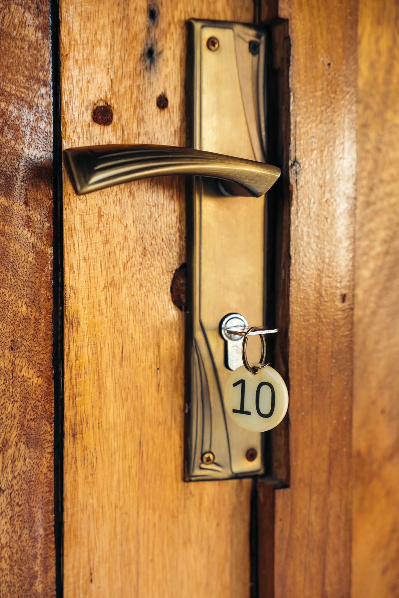 A door with a brass handle and a keyhole marked with the number 10.