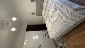 A bedroom with a bed, a wardrobe, and a ceiling light fixture.