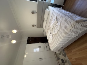 Une chambre à coucher avec un lit, une armoire et un luminaire au plafond.