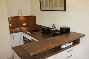 Eine kleine Küche mit eingebautem Spülbecken, Toaster und Kaffeemaschine.