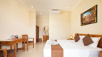 A hotel room with a bed, a desk, a chair, a bathroom, and a painting on the wall.