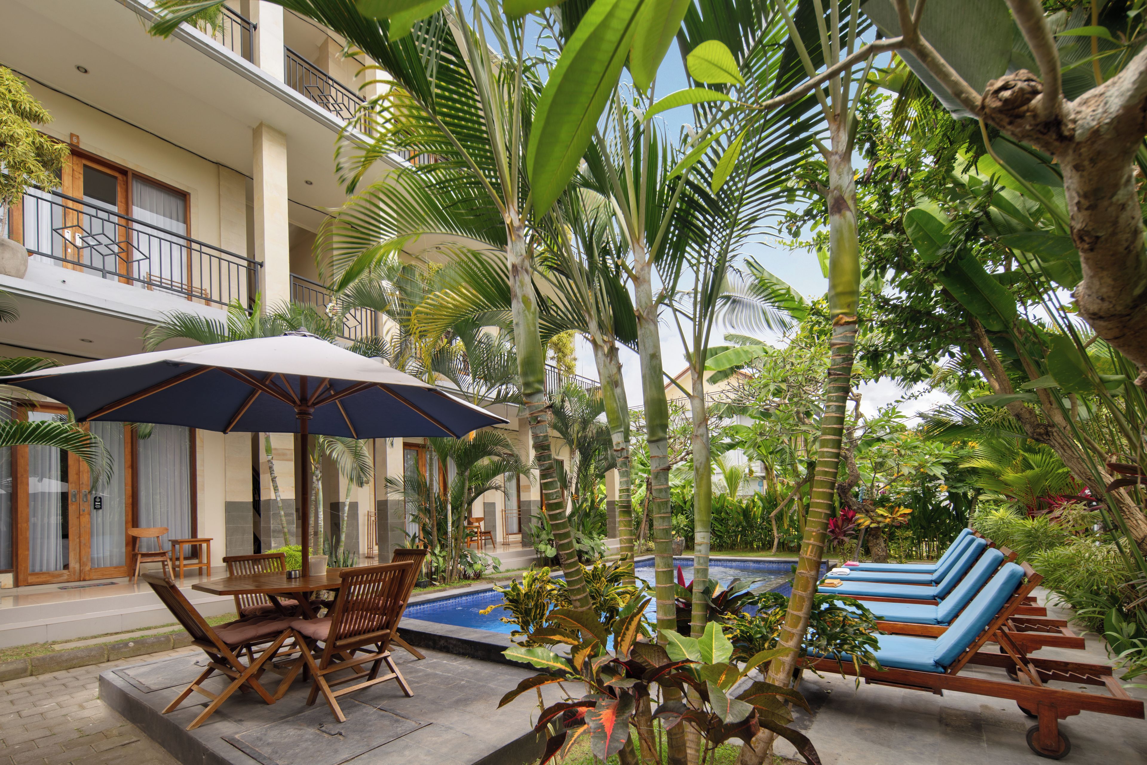 A poolside area with lounge chairs, a table, and an umbrella.