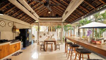 A spacious kitchen with wooden cabinets, a black refrigerator, and a dining area with a wooden table and chairs.
