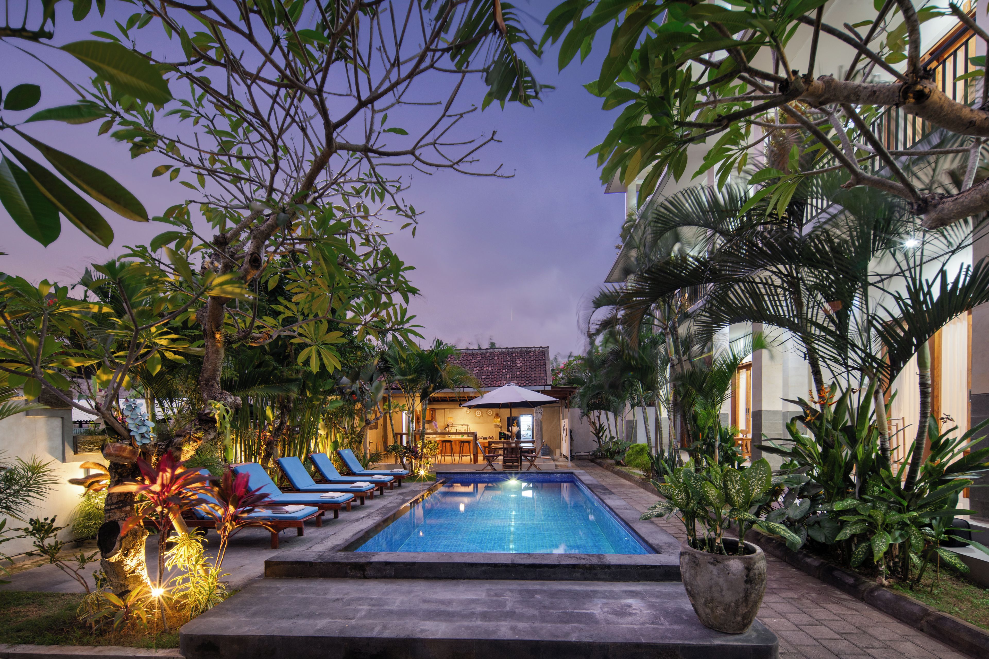 A pool area with lounge chairs and a bar.