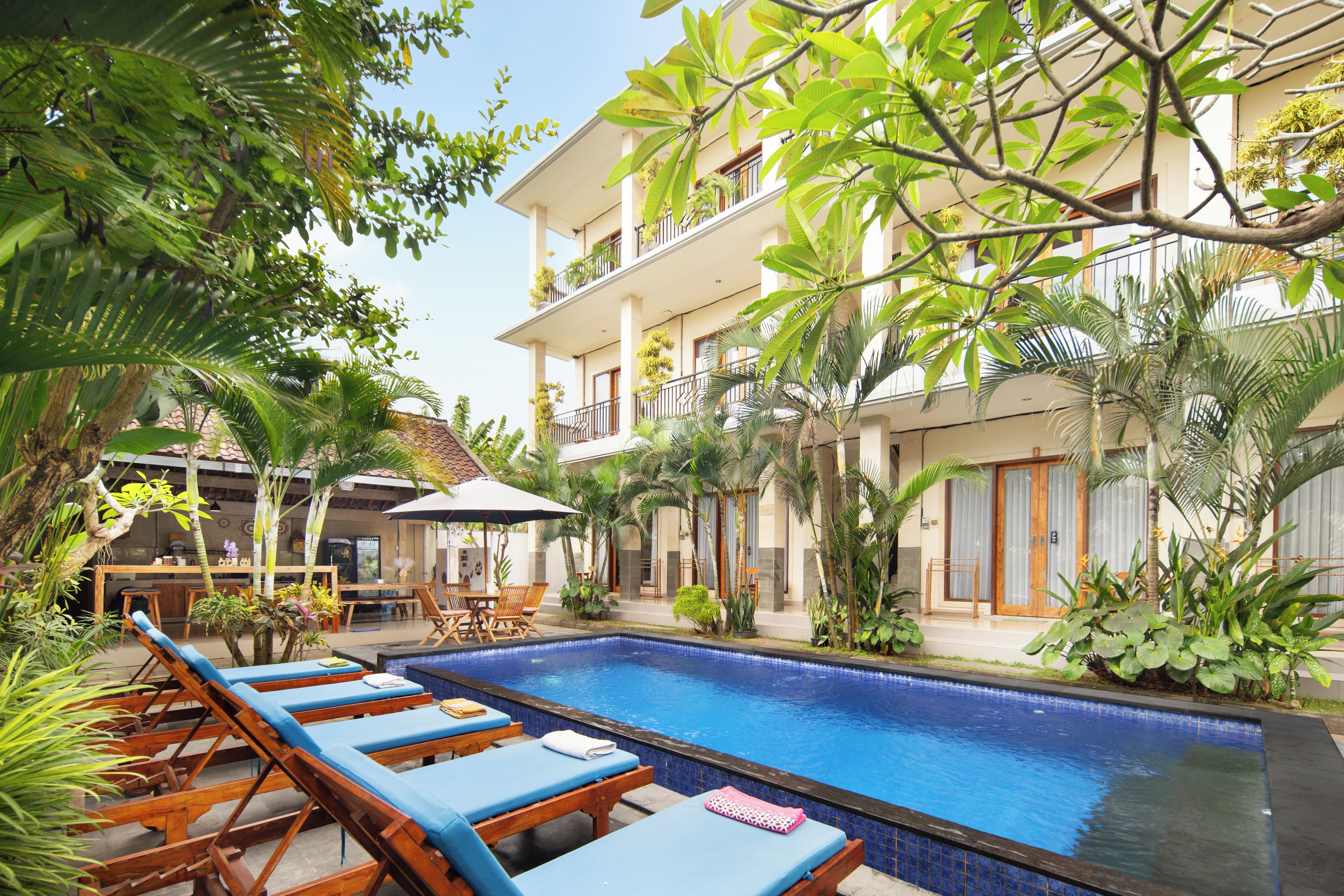A pool area with lounge chairs and a dining area.
