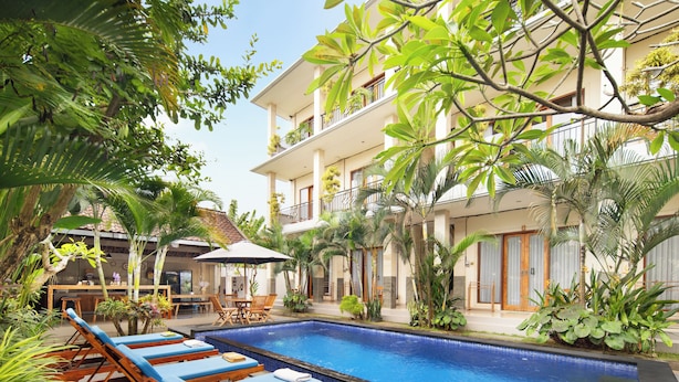 A pool area with lounge chairs and a dining area.