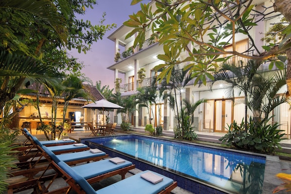 A poolside area with lounge chairs and a pool. - Canggu Nadi 2  (Canggu)