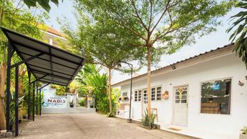A pathway leading to a building with a sign reading 'CANGGU NADI 2 Guest House.'