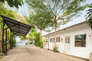 Un camino que lleva a un edificio con un letrero que dice 'CANGGU NADI 2 Guest House'.
