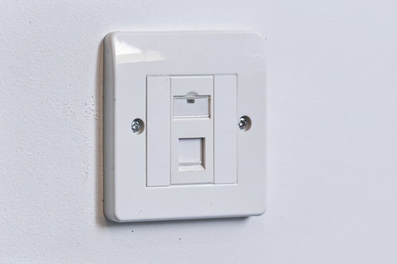 A white electrical switch on a wall.